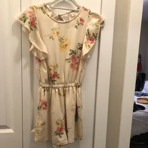 Light yellow floral Aritzia romper with open back.